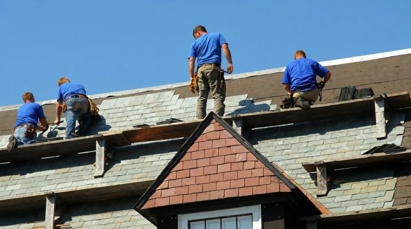 Roof replacement in progress with a team of professional contractors installing new shingles on a residential home in Nashua, NH